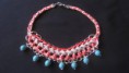 Collar trenzado coral con piedras turquesa.