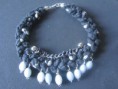 Collar trenza trapillo negro con piedras grises y cadena.